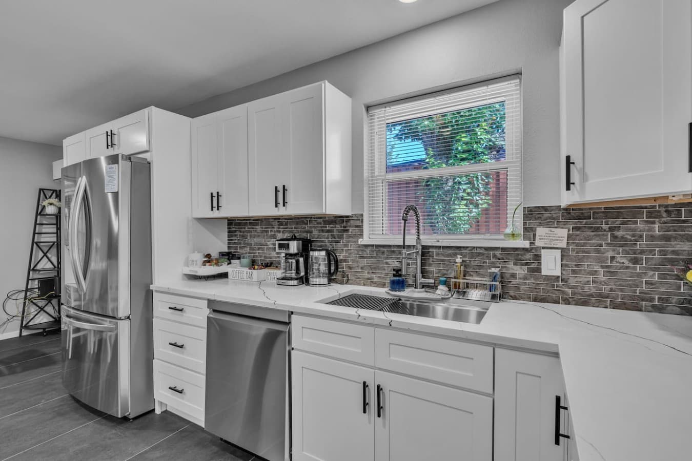 Sunlit workspace featuring stainless steel appliances, stylish finishes, and everything needed for cooking at home.