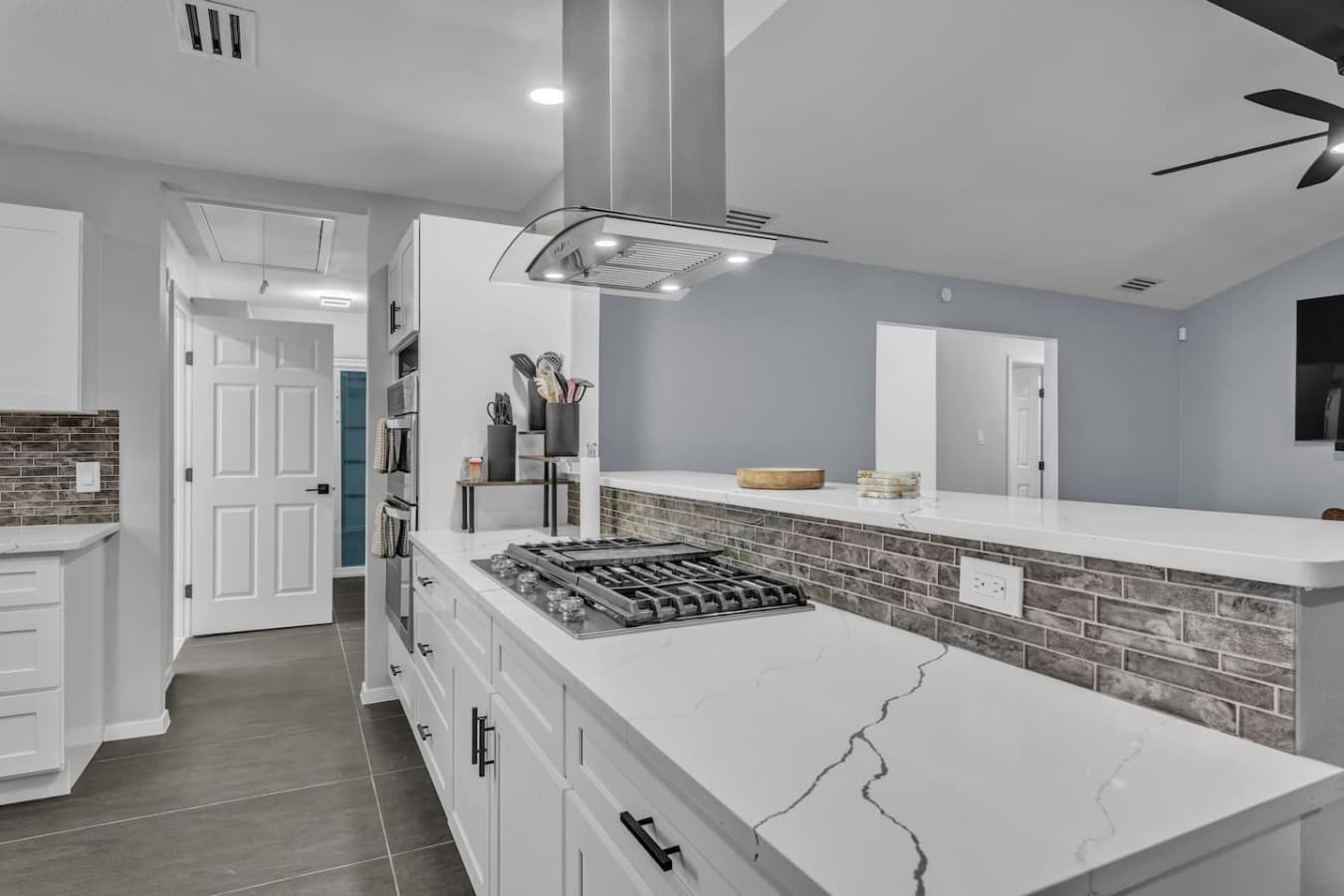 Sleek quartz countertops, premium appliances, and a large cooktop make preparing meals effortless.