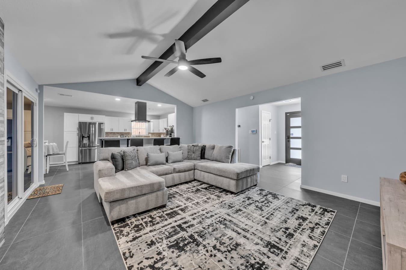 Bright and spacious living room with a plush sectional, soaring ceilings, and an open layout perfect for gathering and relaxing.