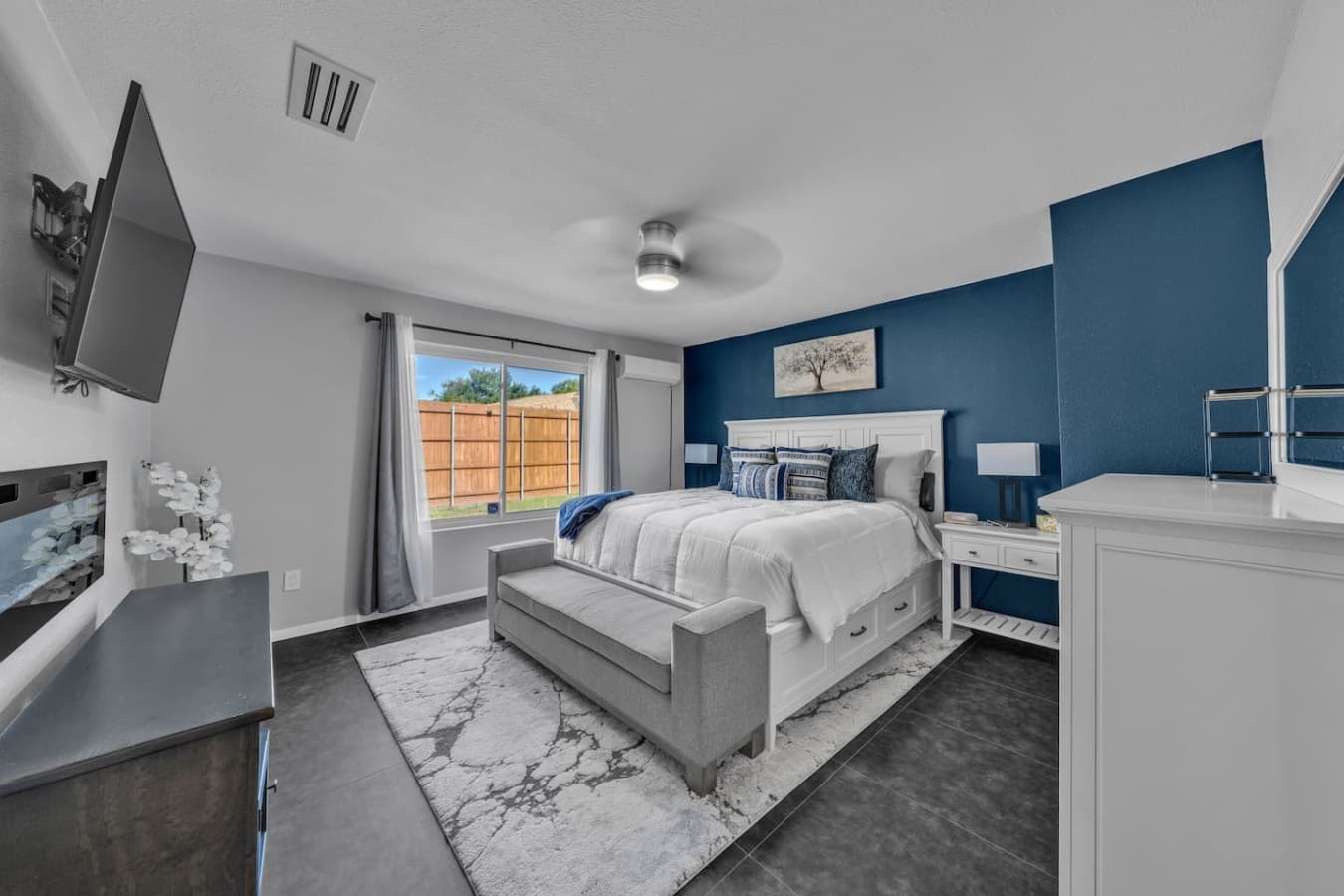 Spacious primary bedroom featuring a king bed, elegant furnishings, and plenty of room to unwind in comfort.