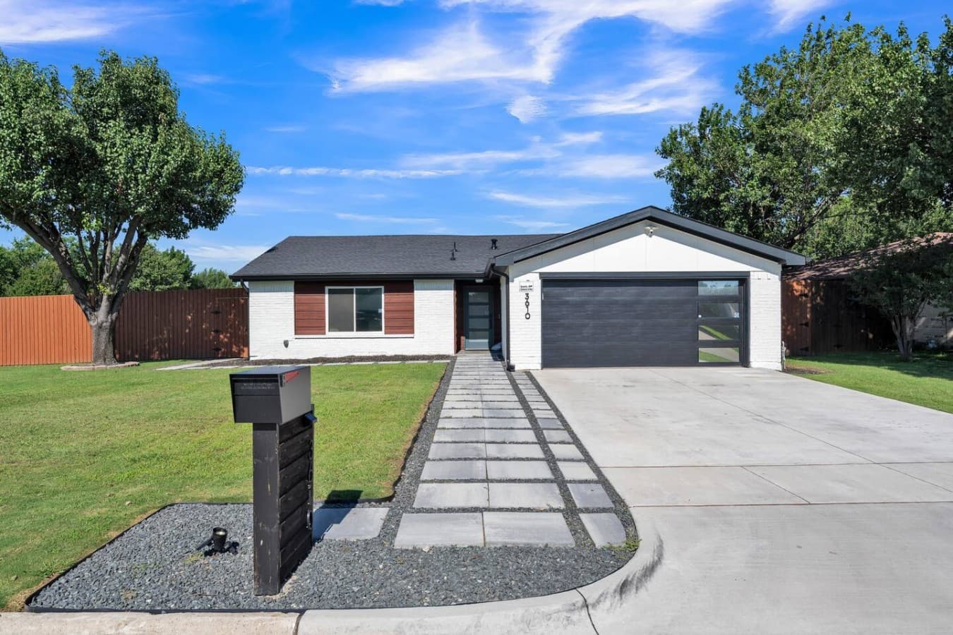Welcoming front exterior with modern curb appeal, a spacious driveway, and easy self check in upon arrival.