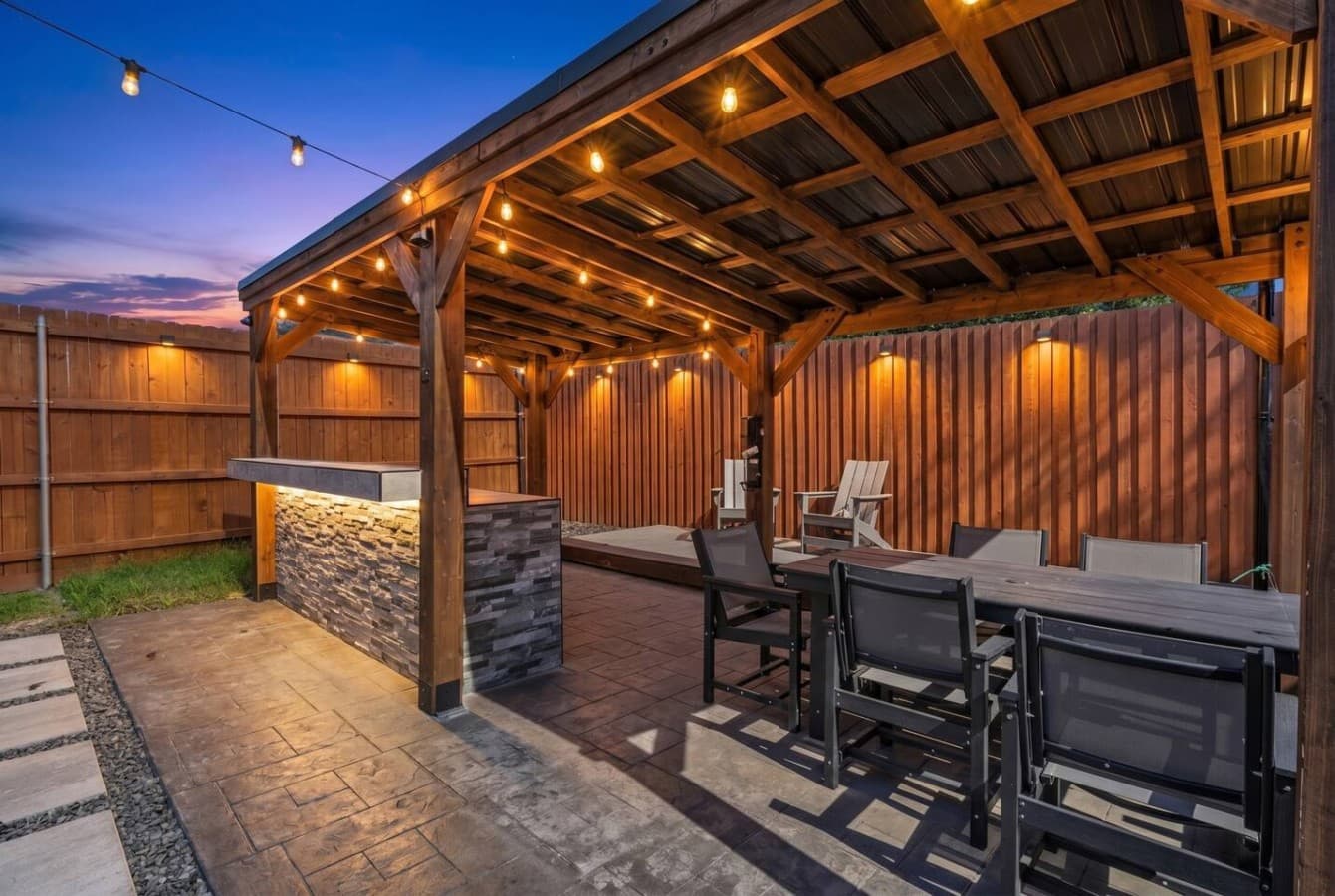 Covered patio with ambient lighting creates the ideal setting for evening meals and memorable outdoor gatherings.