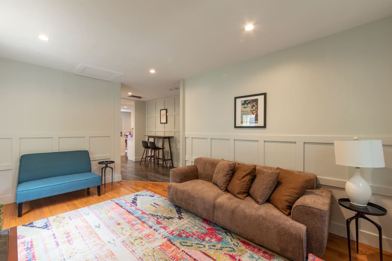 Bright living room with cozy seating and colorful area rug.