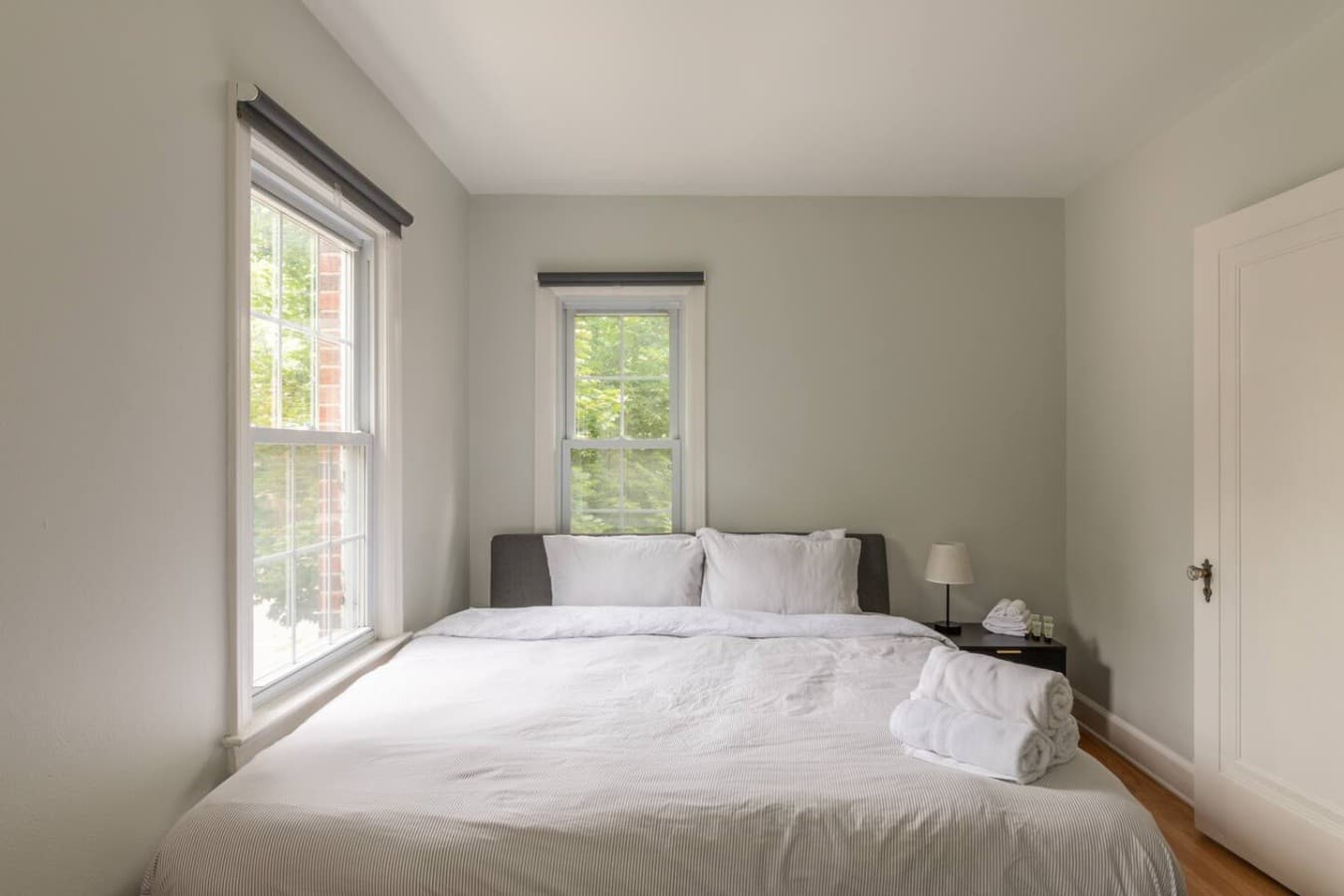Peaceful bedroom with large windows and crisp linens.