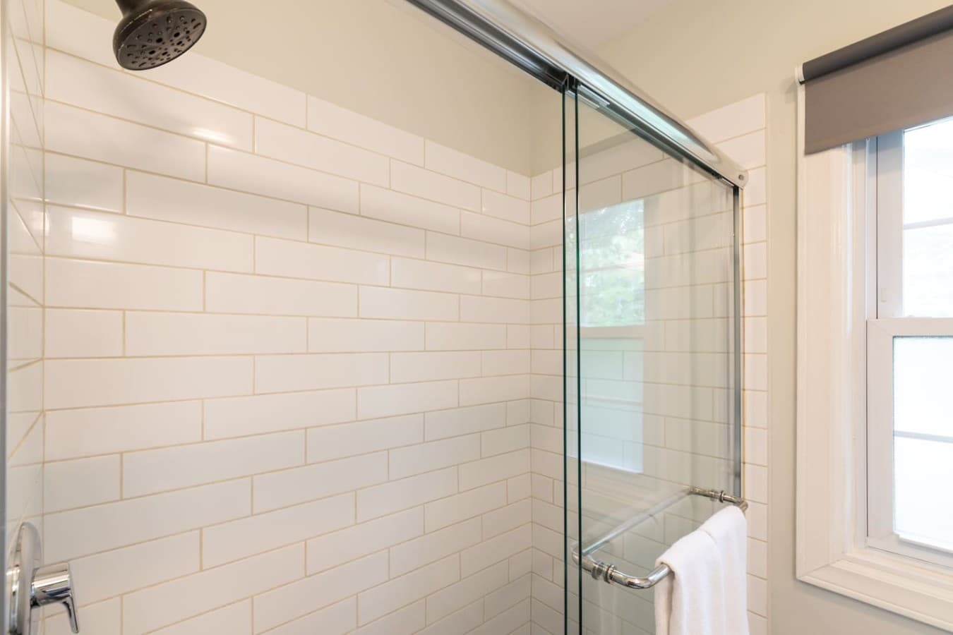 Modern walk in shower with sleek tilework and plenty of natural light.