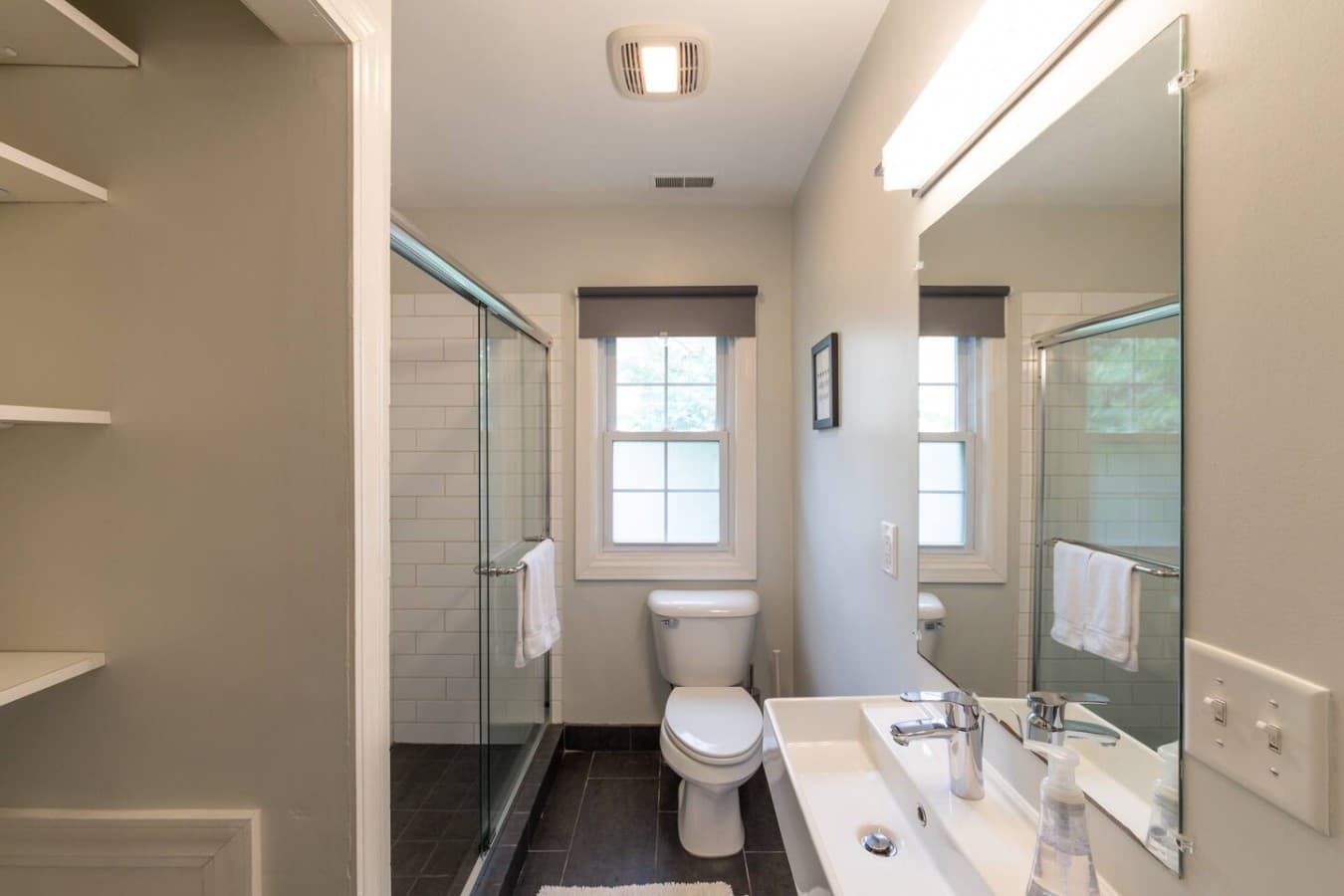 Bright full bathroom with a spacious glass enclosed shower.