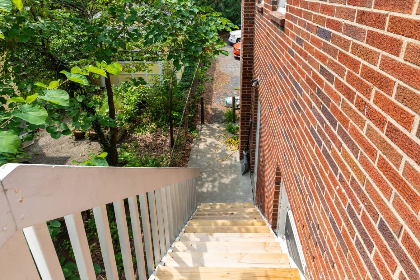 Stairway access to the home surrounded by mature trees and greenery.