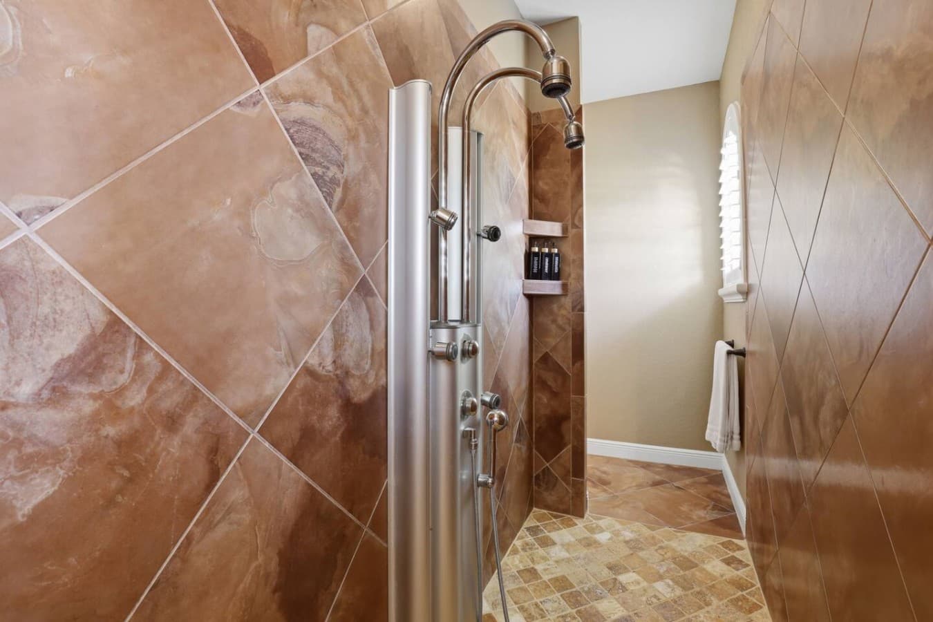 Walk in tiled shower with dual shower heads for a spa like experience.