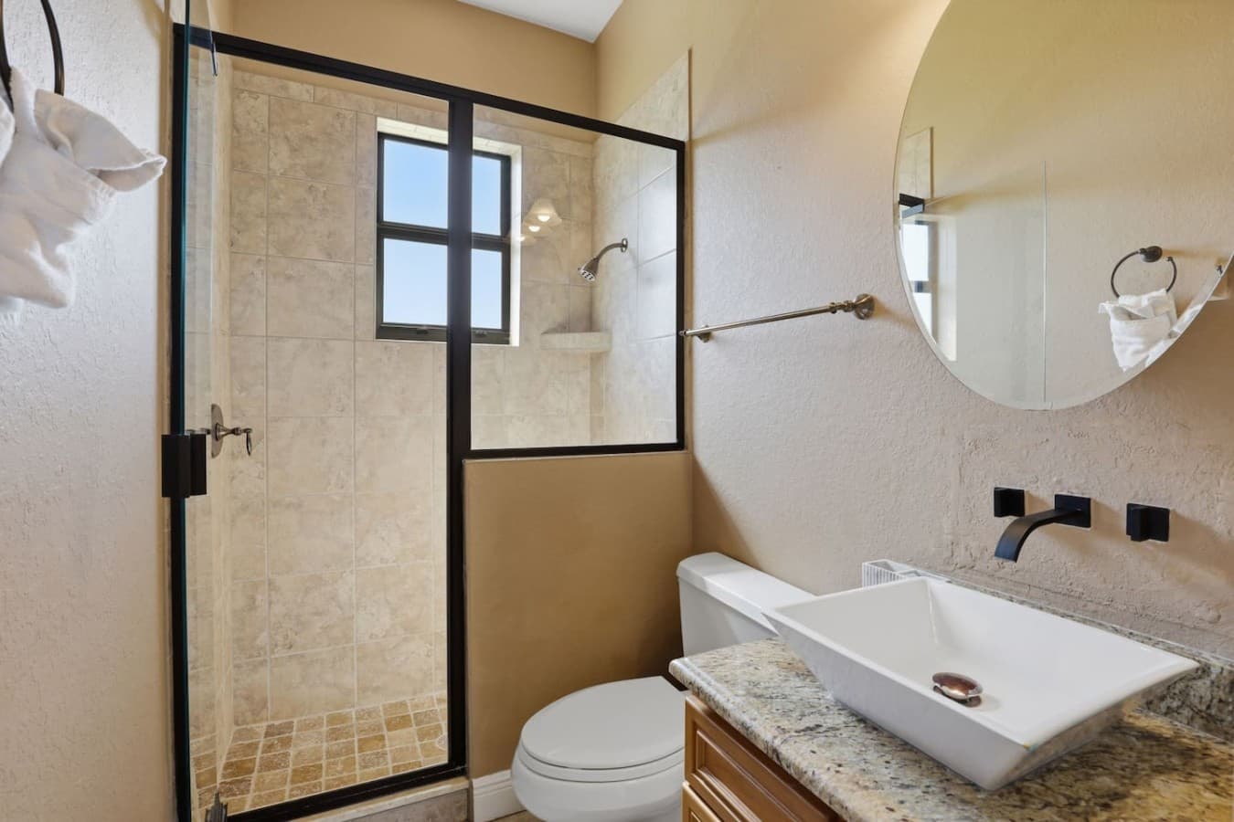 Modern bathroom with a glass walk in shower and updated finishes throughout.