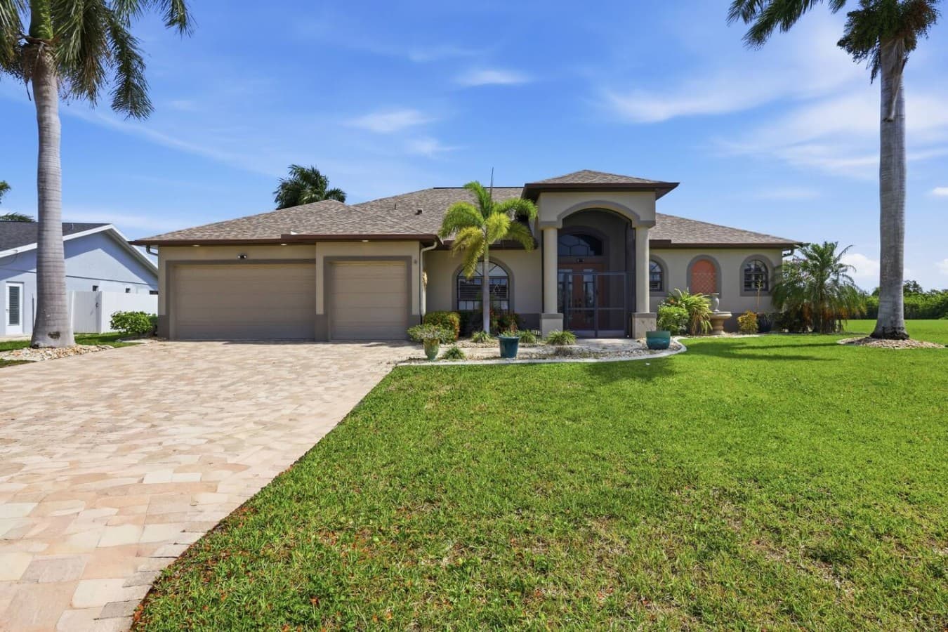 Welcoming front exterior with manicured lawn and elegant entryway.