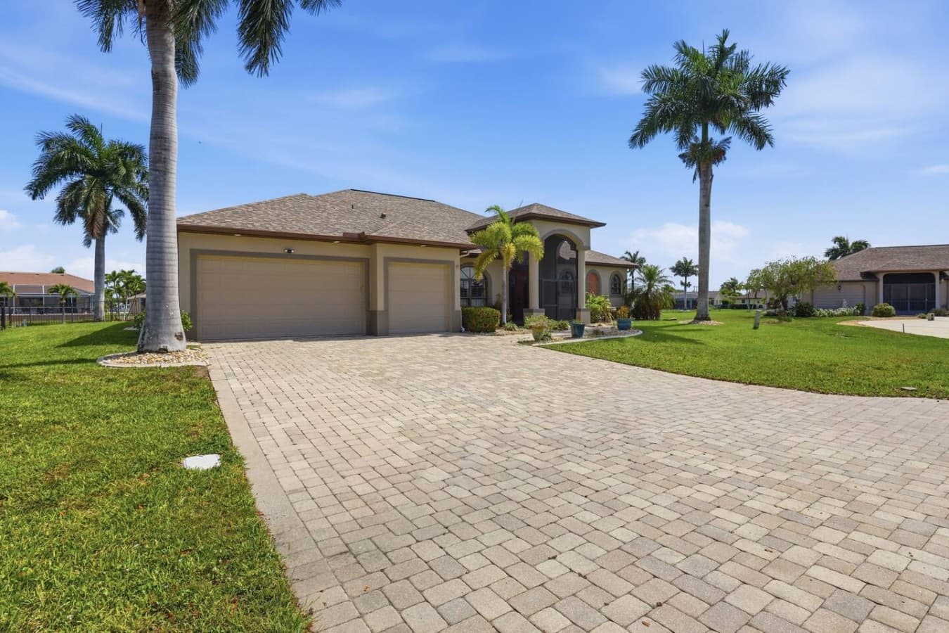 Spacious front driveway with ample parking and palm lined curb appeal.