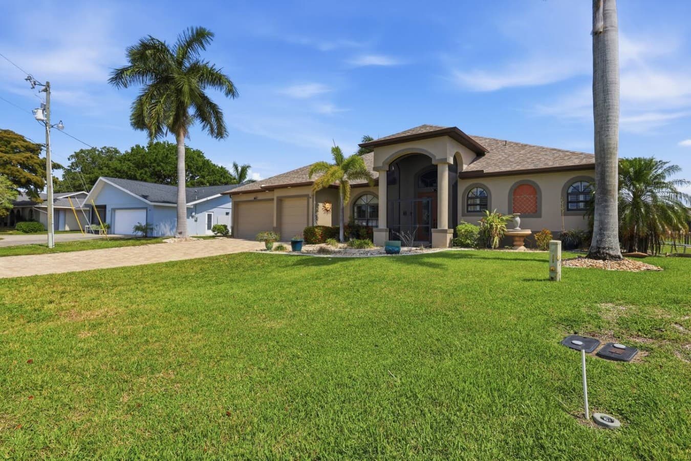 Beautiful waterfront property with tropical landscaping and a spacious front lawn.