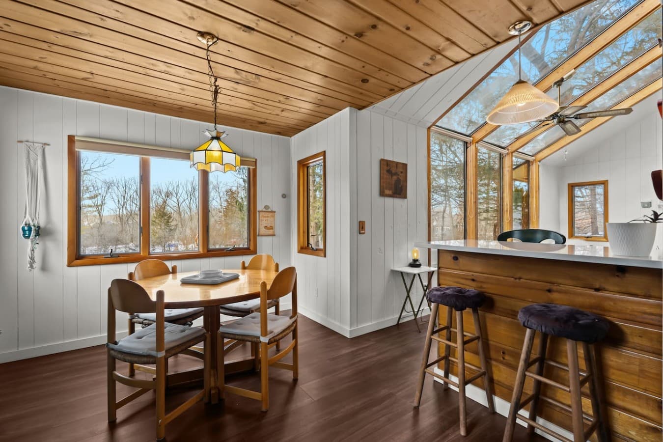 Dining area surrounded by windows and peaceful outdoor views.