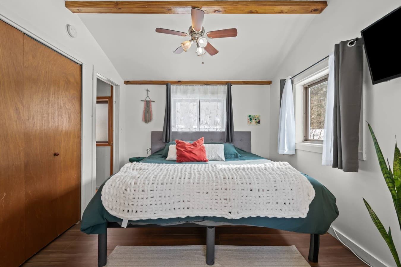 Inviting bedroom with a plush bed and ceiling fan for comfort.