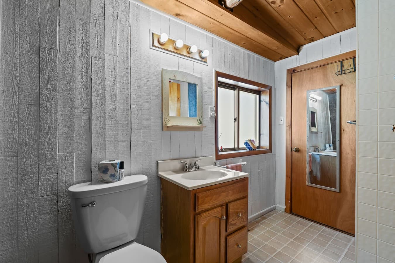 Full bathroom with vanity and warm wood accents.