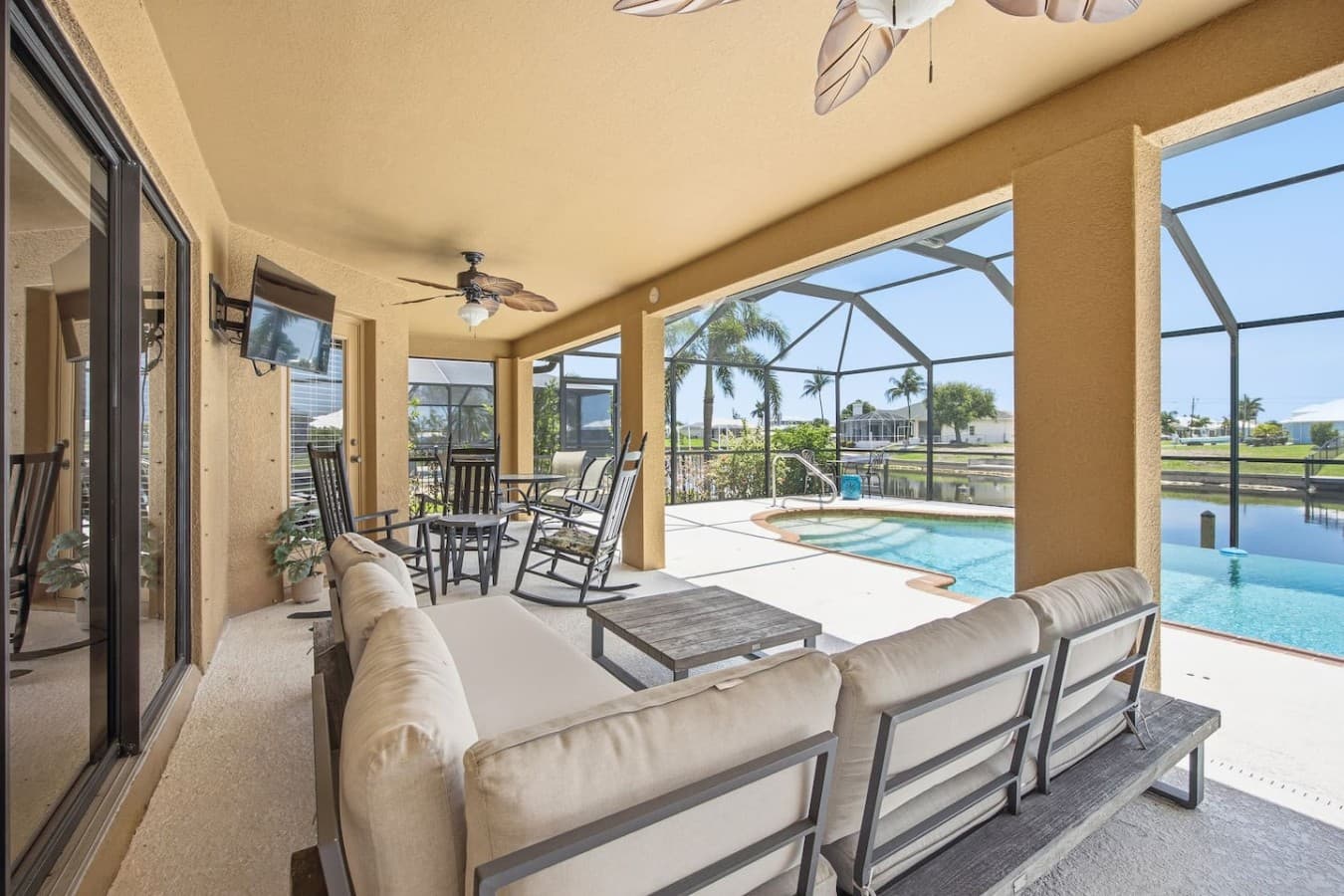 Spacious covered lanai with comfortable seating and seamless access to the screened pool.