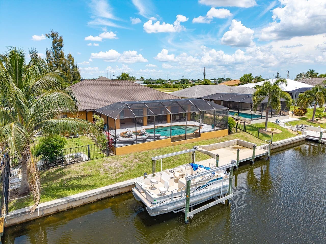 Aerial view showcasing the private dock, screened pool, and beautiful waterfront setting.
