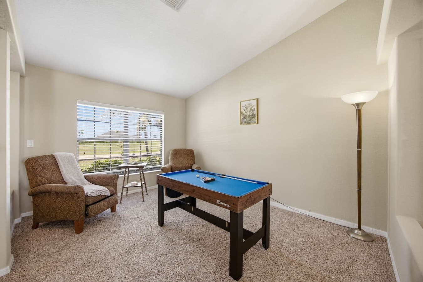Game room with a pool table, comfortable seating, and scenic outdoor views.