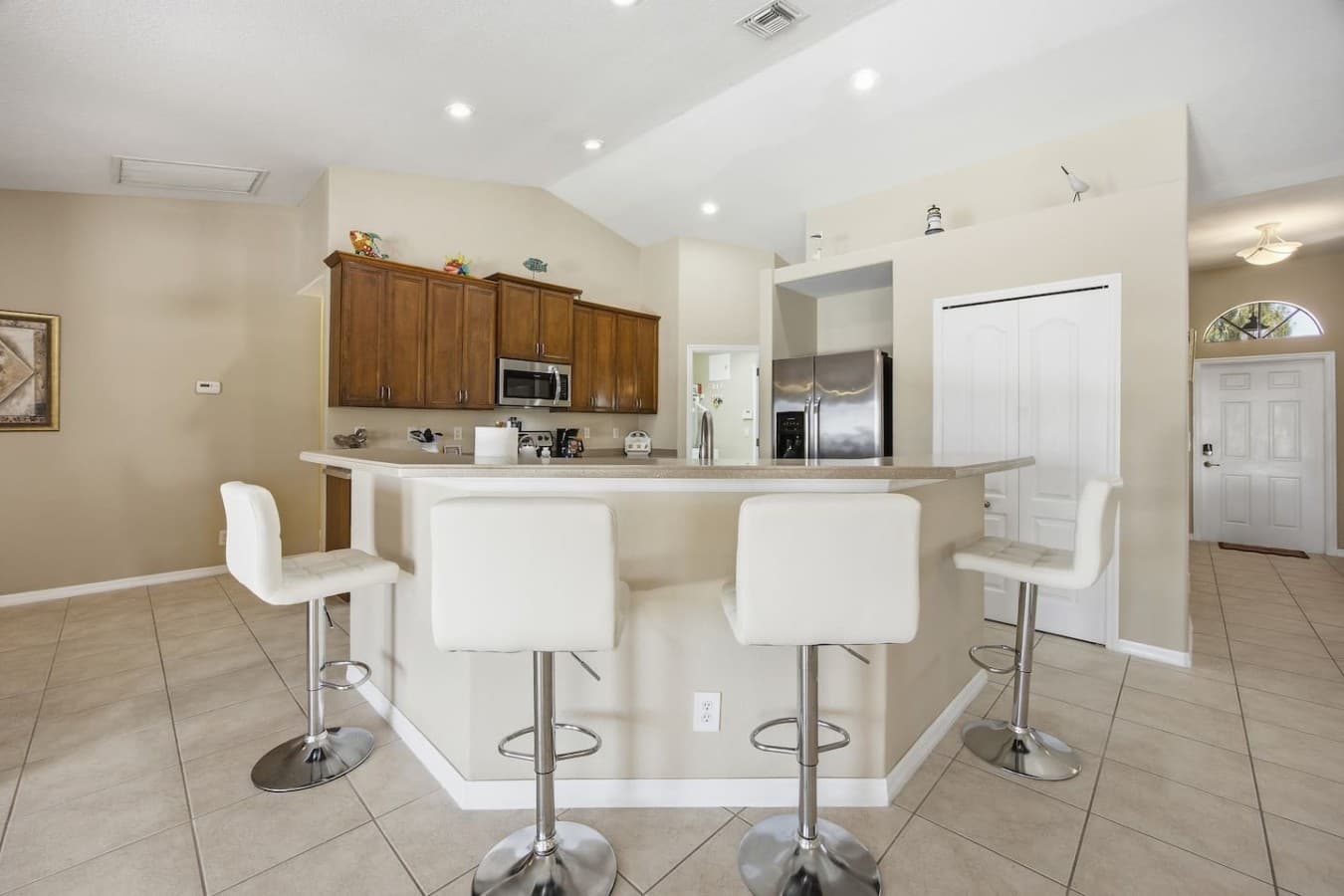 Spacious kitchen featuring a large breakfast bar with seating for four.