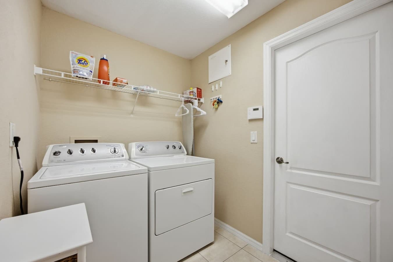 Dedicated laundry room with a full-size washer and dryer and convenient built-in shelving.