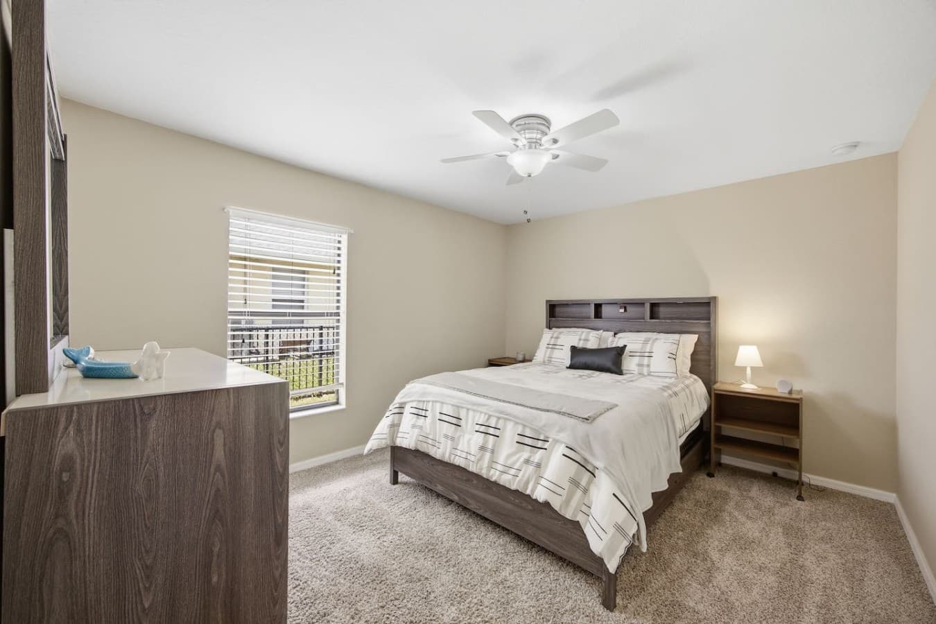 Comfortable guest bedroom with plush carpeting and a ceiling fan for added comfort.