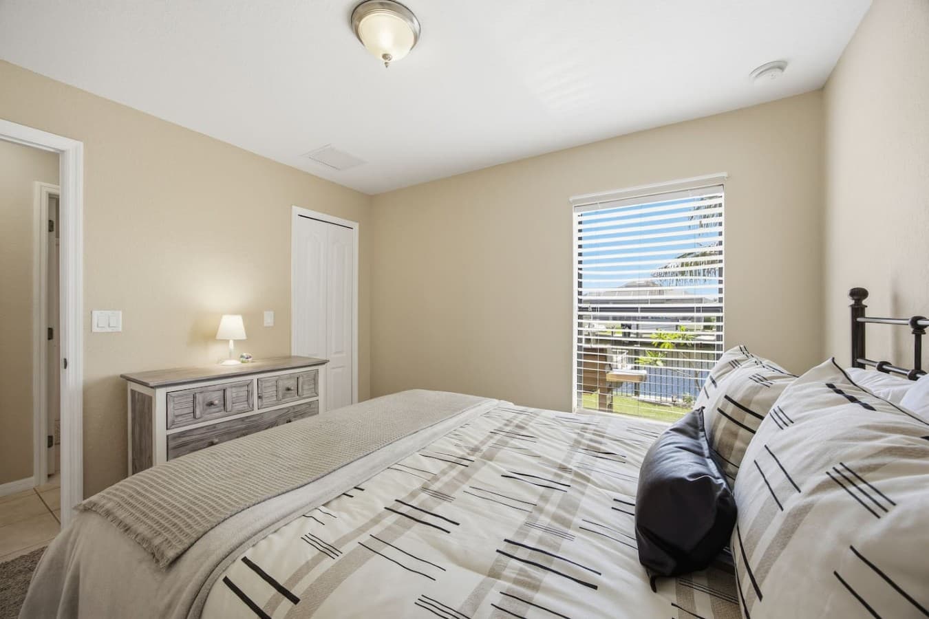 Inviting guest bedroom featuring a dresser, large window, and ample closet space.