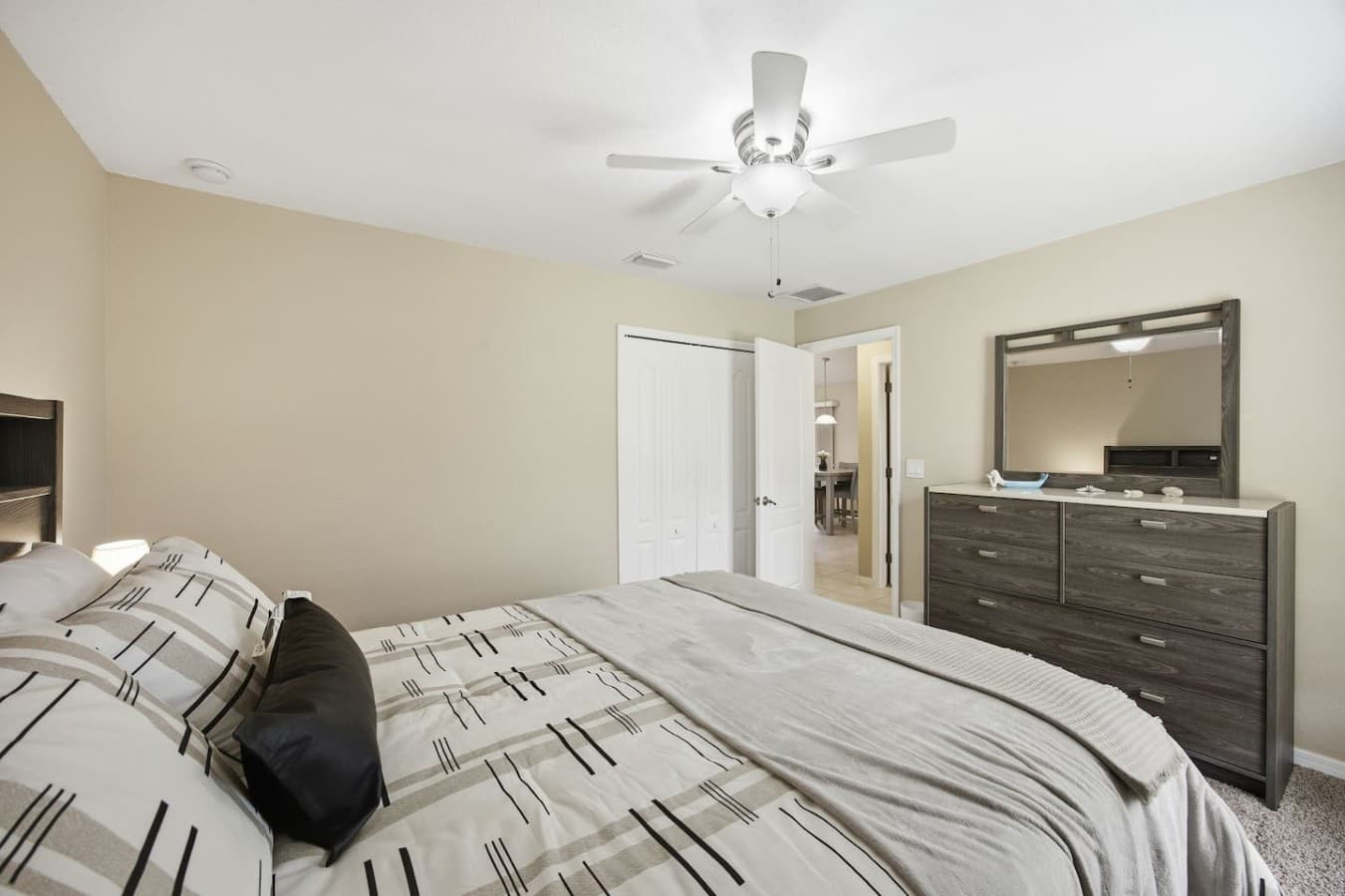Bright guest bedroom featuring ample space, modern furnishings, and easy access to the adjoining bathroom.
