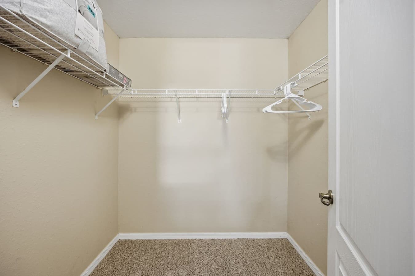 Spacious walk-in closet with built-in shelving and plenty of room for storage.