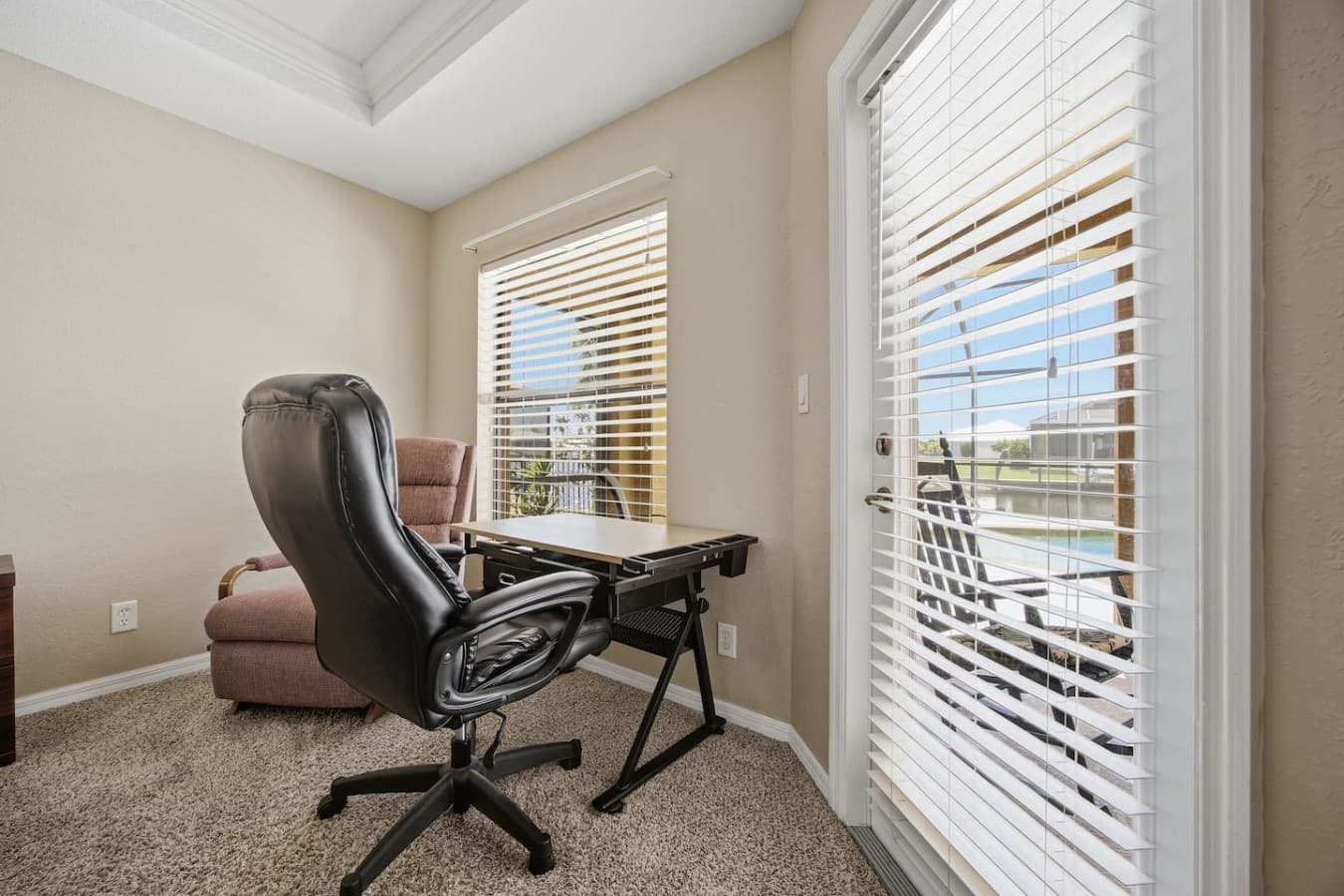Flexible office nook with a desk, comfortable seating, and direct access to the covered lanai.