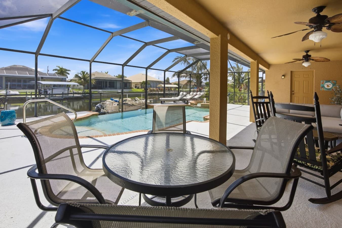 Covered outdoor dining area overlooking the private screened pool and waterfront views.