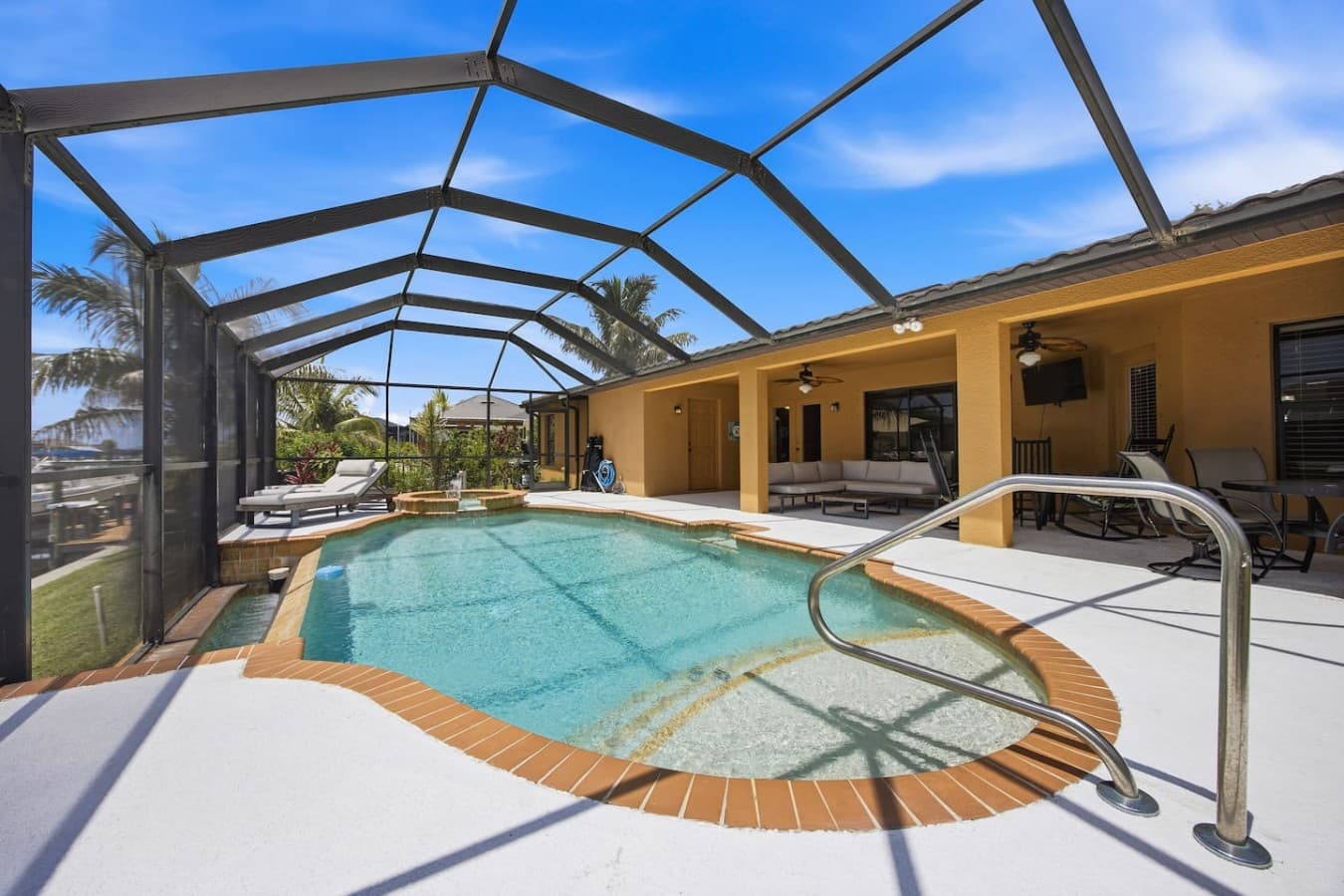 Resort-style pool and spa with seamless indoor-outdoor living and waterfront views.