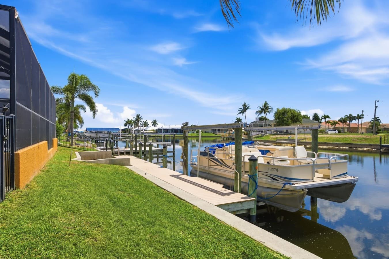 Private boat dock with waterfront access, manicured lawn, and beautiful canal views.