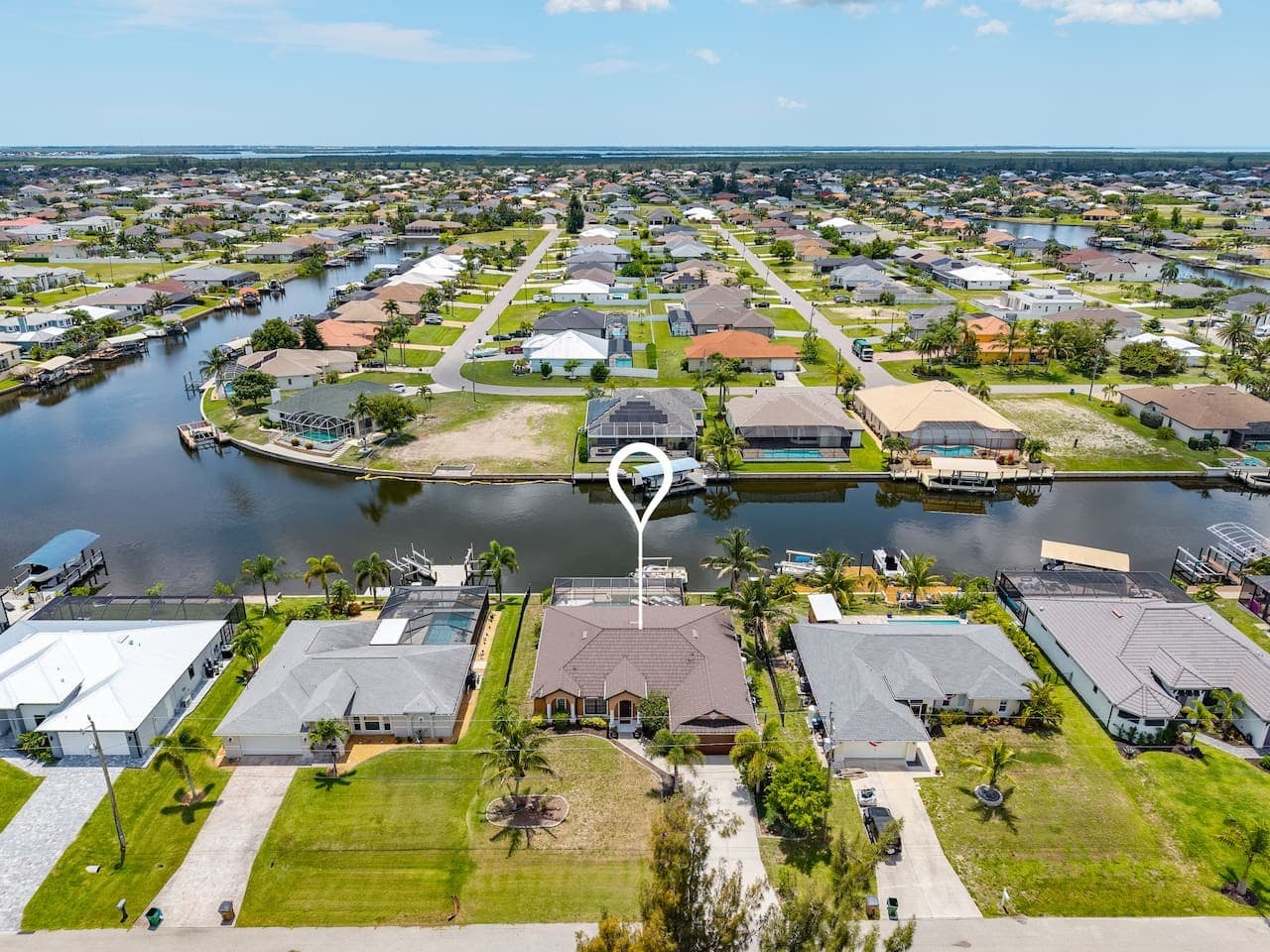 Aerial view highlighting the home's prime canal-front setting and surrounding neighborhood.