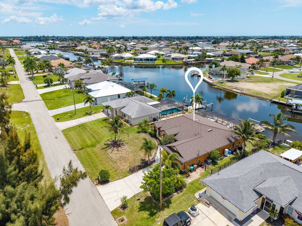 Elevated aerial perspective showcasing the home, spacious yard, and desirable waterfront location.