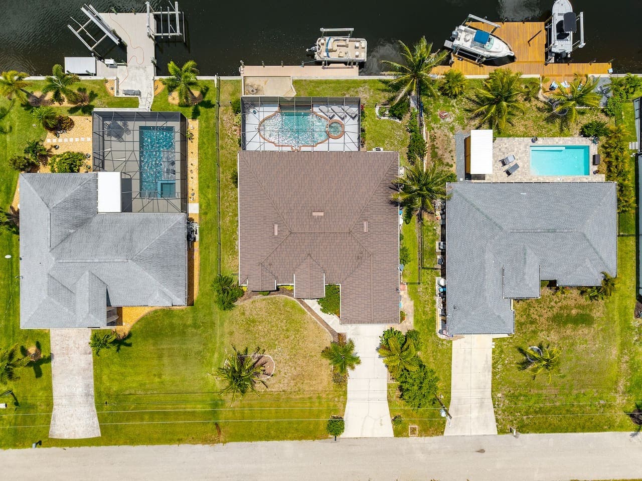 Aerial view showcasing the home, private screened pool, and waterfront location.