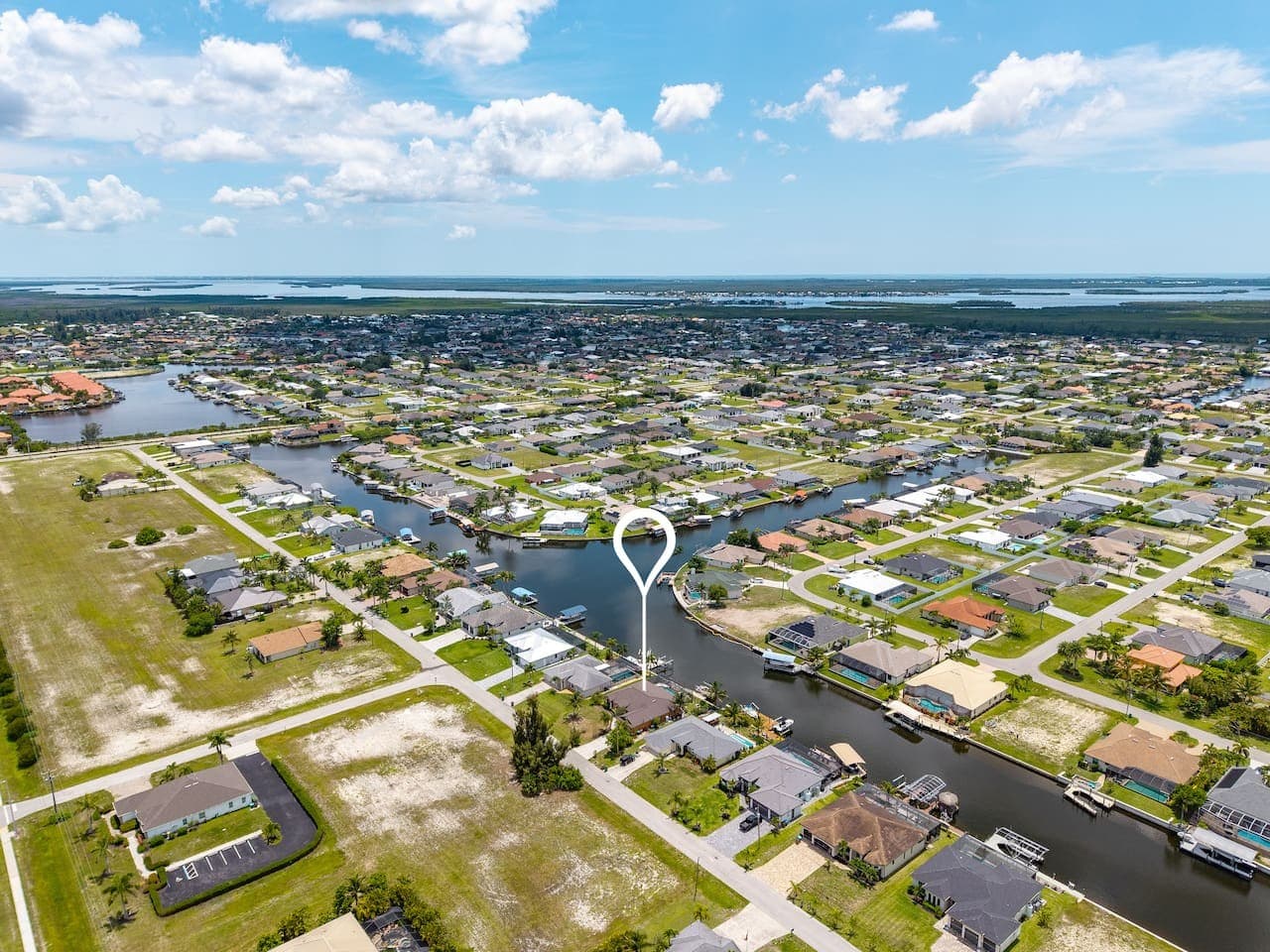 Expansive aerial view of the surrounding waterfront community and canal system.