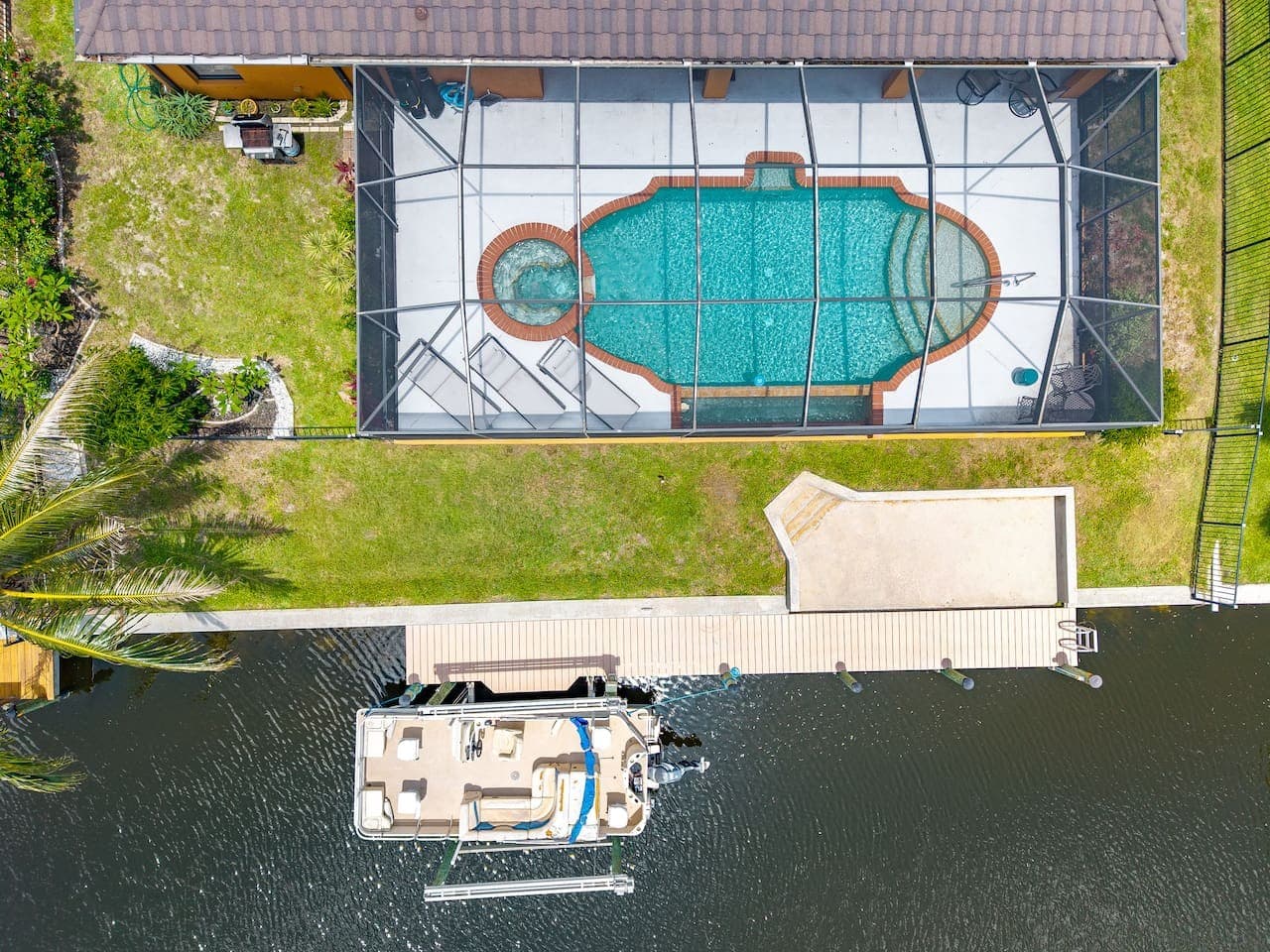 Overhead view highlighting the screened pool, private dock, and direct canal access.