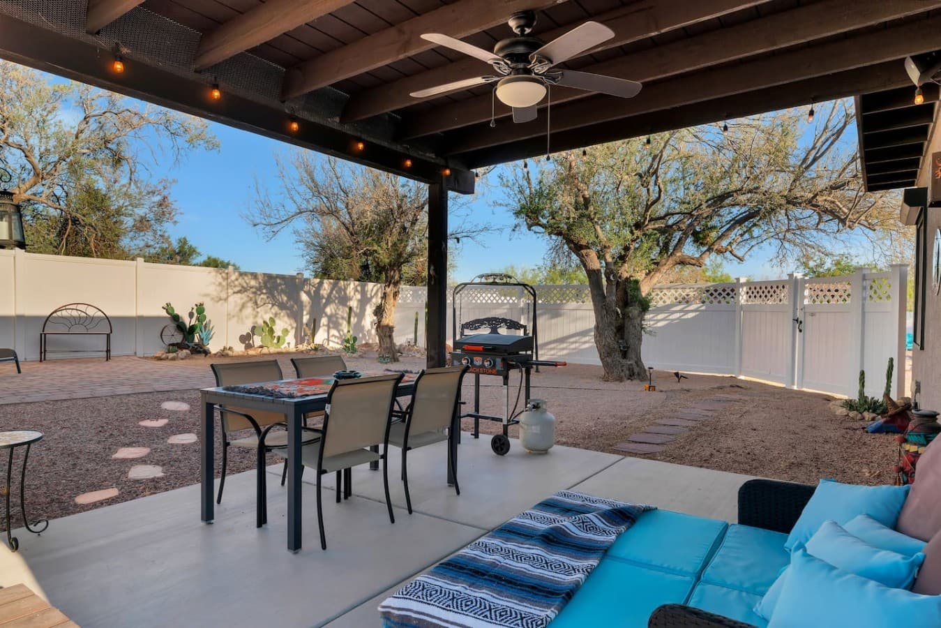 Covered outdoor patio with dining space, string lights, and room to relax outdoors.
