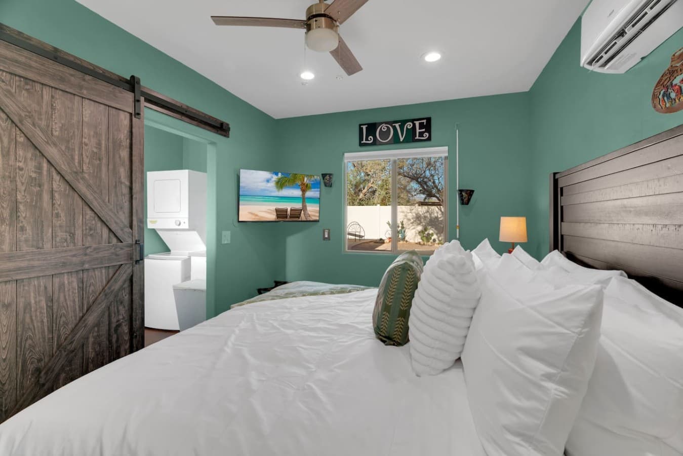 Peaceful bedroom with soft linens and a view of the outdoor space.