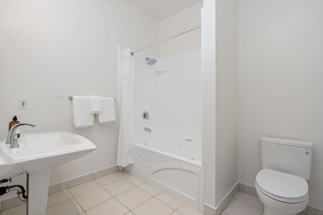 This is the private bathroom inside the room you will be renting featuring a clean shower and tub combination with bright, simple finishes.