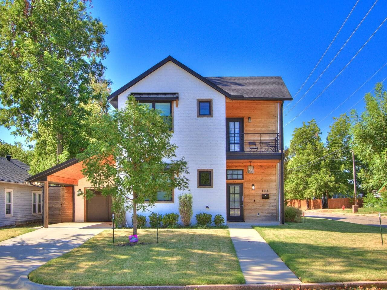 Modern two story home with striking architectural details, warm wood accents, and an inviting front entrance.