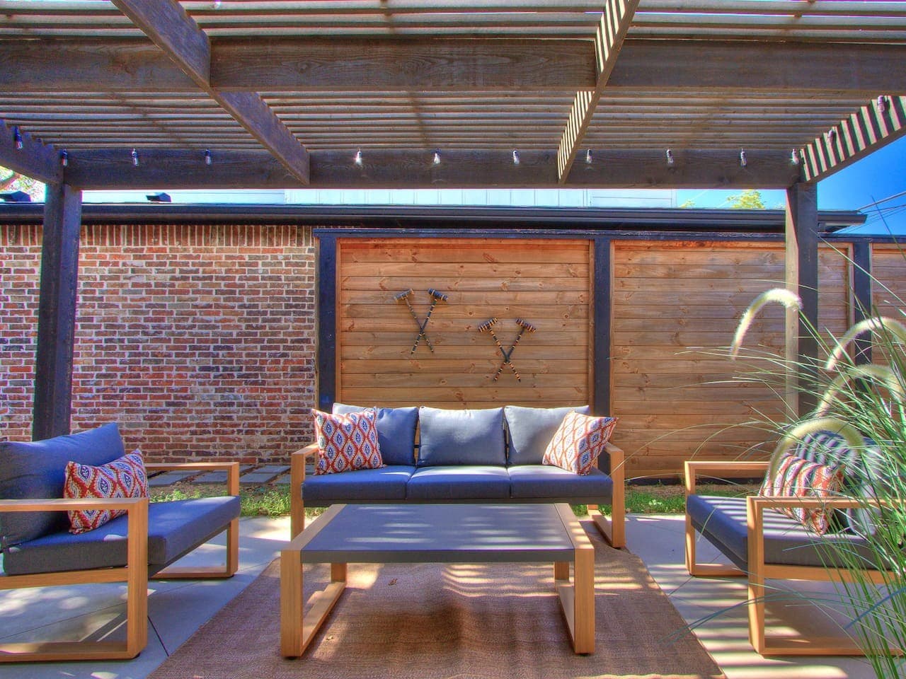Relax beneath the pergola in a comfortable outdoor lounge designed for conversation and quiet afternoons.