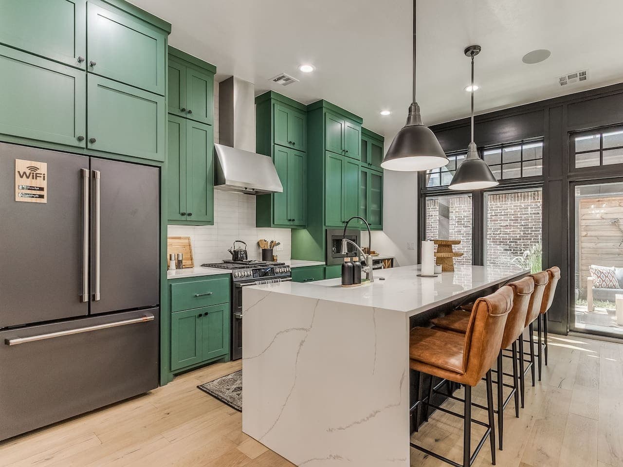 Spacious kitchen with a waterfall island, leather bar stools, and plenty of room for preparing meals together.