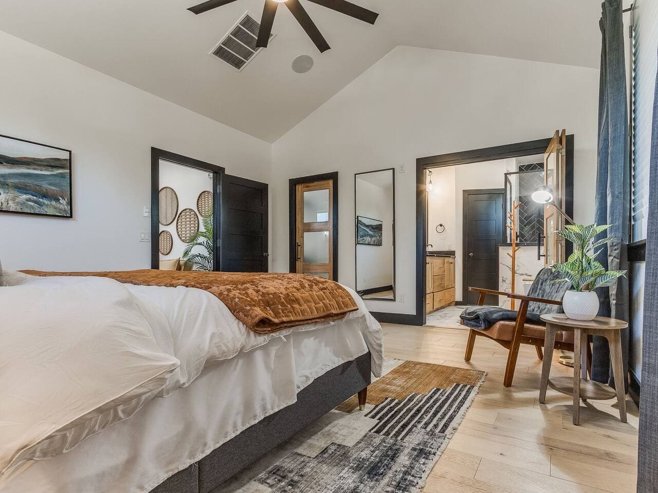 Relax in the spacious primary suite featuring vaulted ceilings, a ceiling fan, and a seamless connection to the ensuite bathroom.