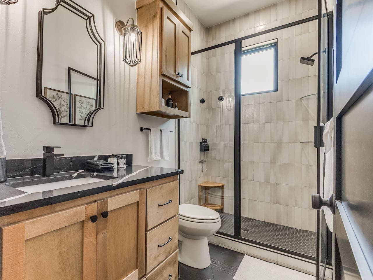 Stylish full bathroom with a walk in shower, warm wood cabinetry, and thoughtfully selected modern finishes.