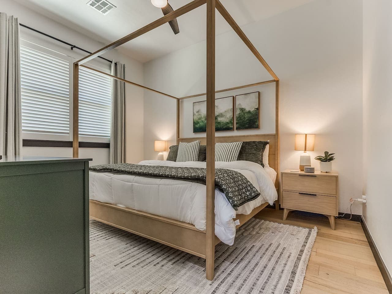 Inviting bedroom with a beautiful canopy bed, soft layered linens, and warm bedside lighting.