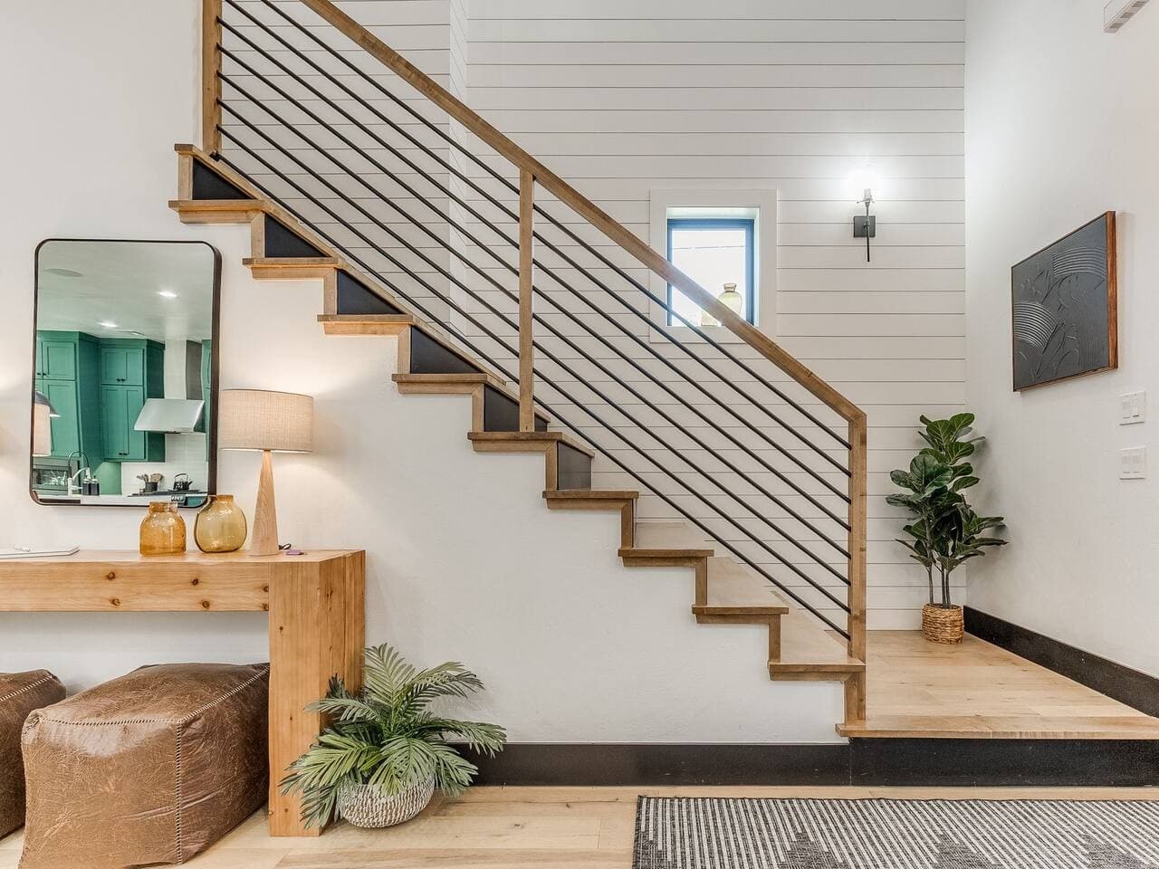 Modern staircase with warm wood steps and sleek railing adds character to the open concept interior.