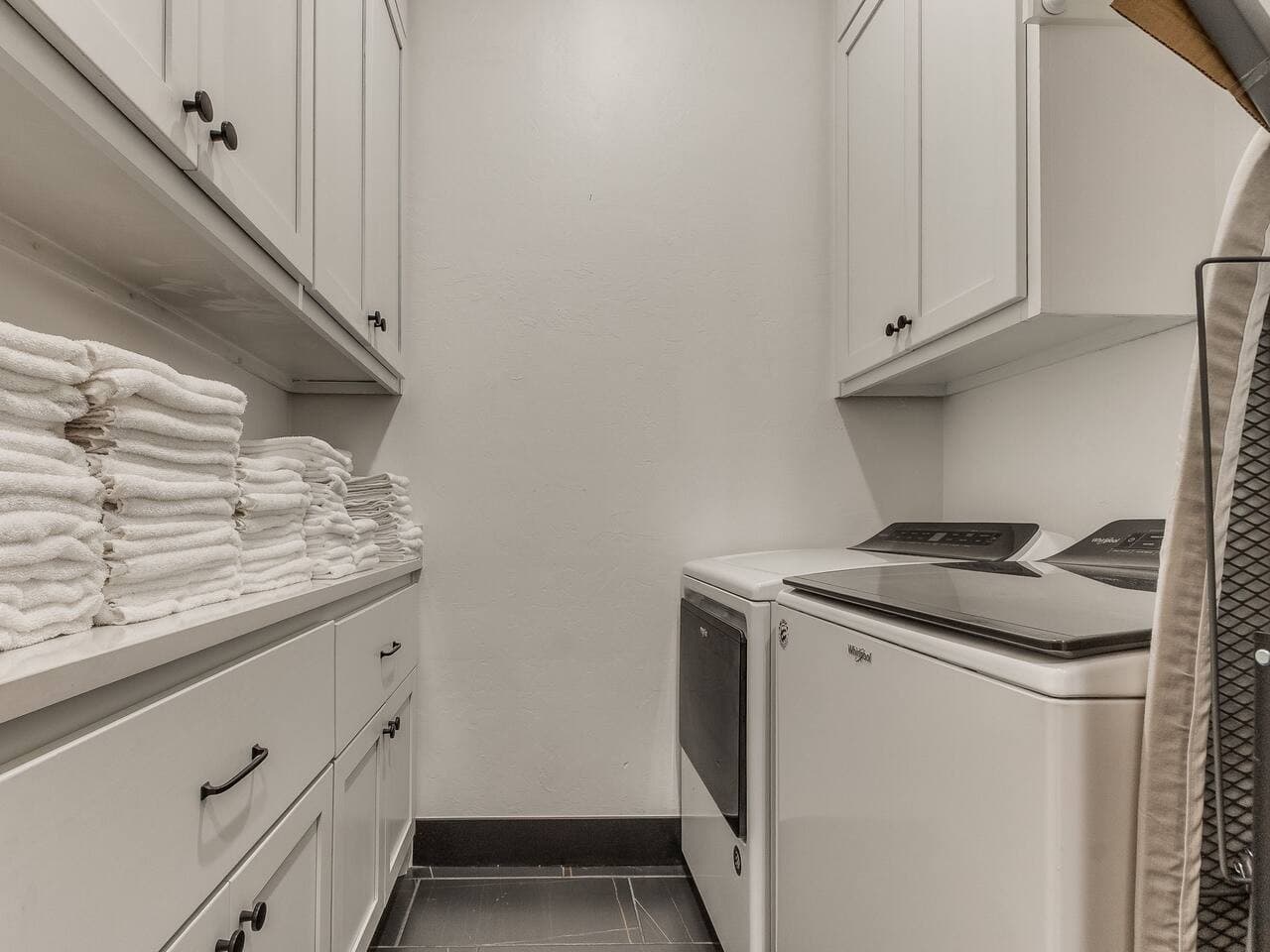 Convenient laundry room with a full size washer and dryer, built in cabinetry, and plenty of storage space.