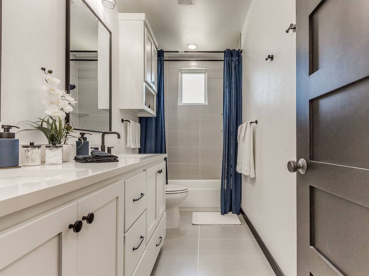Bright full bathroom with a spacious vanity, modern finishes, and a convenient shower and tub combination.