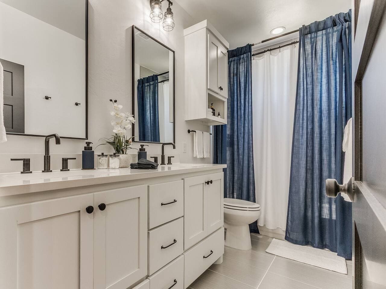 Fresh and inviting bathroom featuring ample counter space, generous storage, and a shower and tub combination.